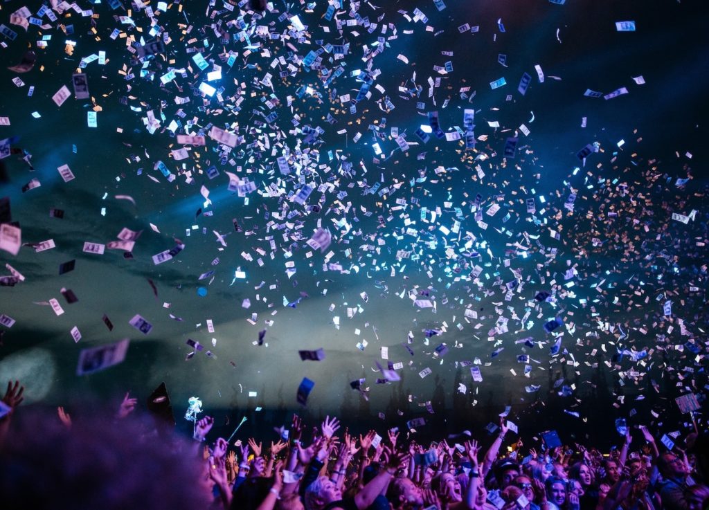 People standing below confetti flying in the air